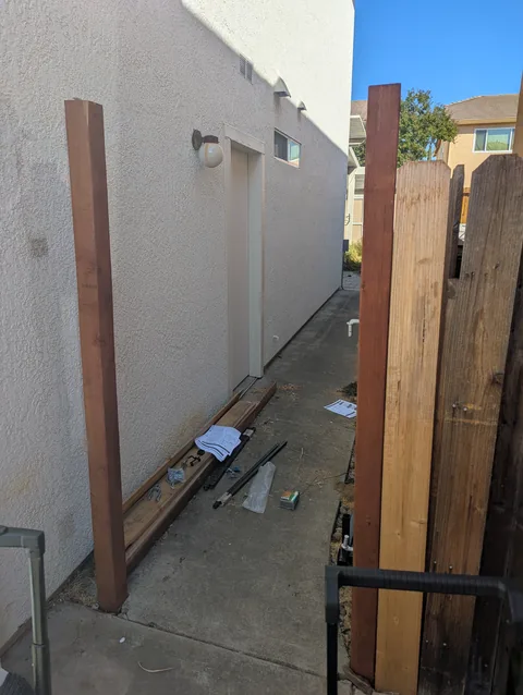 Backyard gate opening before the new wooden gate