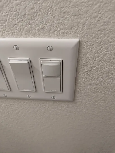 Motion sensor switch installed in a bathroom switch bank