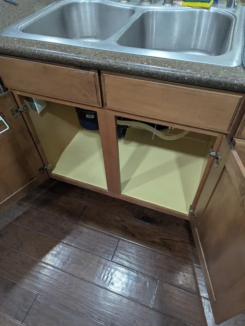 Rebuilt cabinet base under the sink after water damage repair
