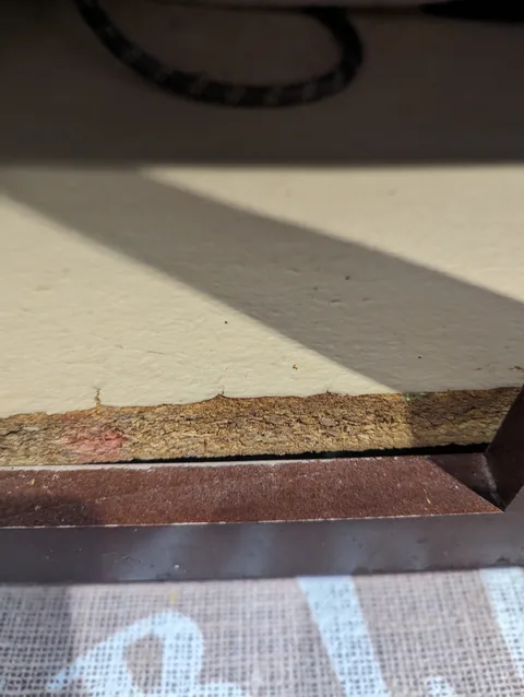 Water damaged cabinet base under a kitchen sink before repair