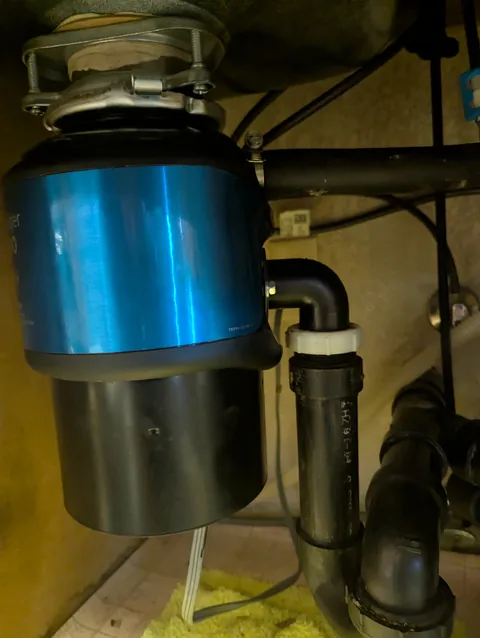 New garbage disposal installed under a kitchen sink